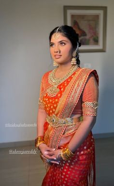 a woman in an orange and red sari