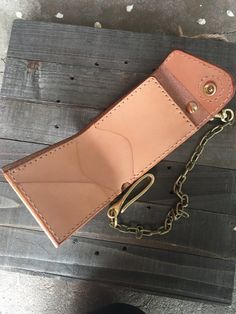 a brown leather wallet sitting on top of a wooden table next to a pair of shoes