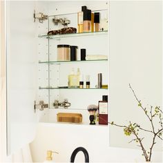 a bathroom shelf filled with lots of different types of cosmetics and personal care items next to a mirror