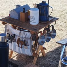 a picnic table with utensils and cooking utensils hanging from the rack