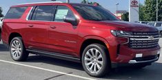 a red chevrolet suburban parked in a parking lot