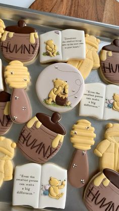 decorated cookies in the shape of winnie the pooh characters on a cookie sheet with writing