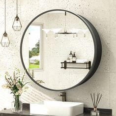 a round mirror hanging on the wall above a sink