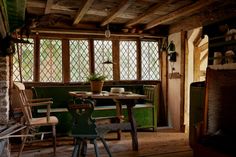 a table and chairs in a room with wood beams on the ceiling, windows to the outside