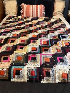 a bed with a large quilt on top of it