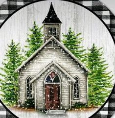 a christmas ornament with a church and evergreen trees on it's side