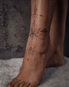 a woman's foot with a flower tattoo on her left side and the bottom part of her leg