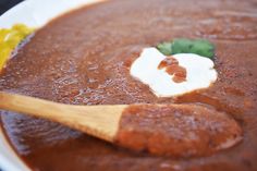 a wooden spoon in a bowl filled with soup