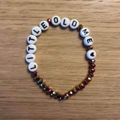 a beaded bracelet with words written on it and beads in the shape of a heart