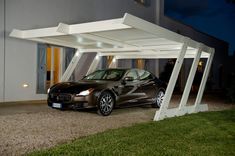 a car parked in front of a house with white columns on the roof and windows