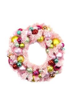 a pink wreath with ornaments hanging from it