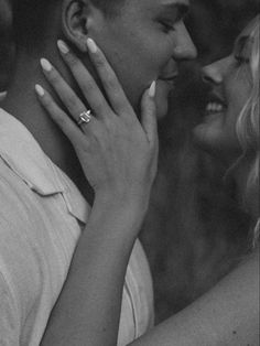 black and white photograph of a man kissing a woman's face with his hand on her cheek