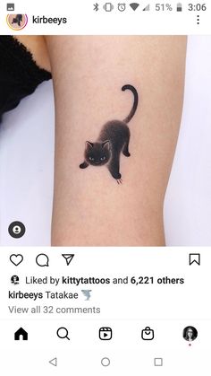 a small black cat tattoo on the arm