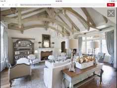 a living room filled with lots of furniture and a chandelier hanging from the ceiling