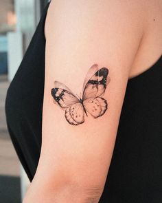 a woman's arm with a butterfly tattoo on the left side of her arm