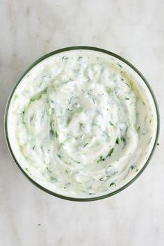 a bowl filled with white sauce on top of a table