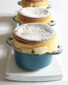 three donuts sitting on top of a blue pan filled with powdered doughnuts