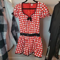 a red and white polka dot dress hanging on a rack