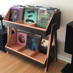 a book shelf with several books on it in front of a wall mounted speaker system