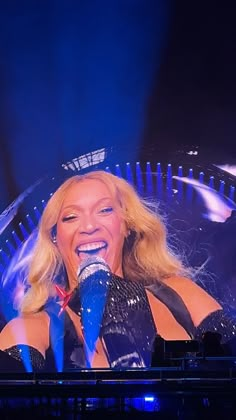 a woman with blonde hair singing into a microphone