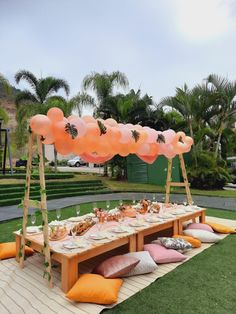 a picnic table with balloons and food on it