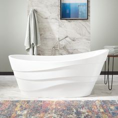 a bathtub sitting on top of a rug in a bathroom