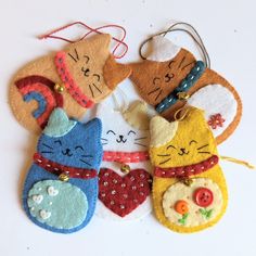 four felt ornaments with cats and hearts on them