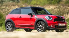 a red mini countryman parked on the side of a road