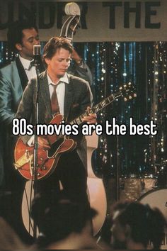 a man playing guitar in front of a microphone with the words 80's movies are the best