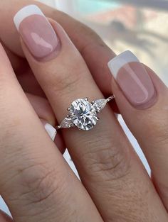 a woman's hand with a ring on it and a diamond in the middle