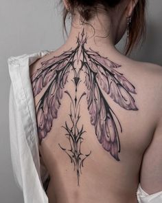 the back of a woman's neck with an intricate tattoo design on her chest