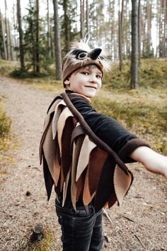 a young boy wearing a costume in the woods