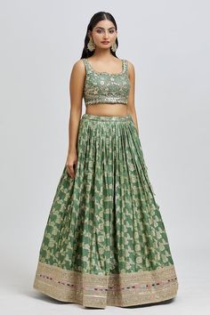 Mud green attached cancan lehenga with all over floral pattern and golden embroidered hem. Paired with a padded blouse with all over embroidery using beads, mirror, zari, sequin and cutdana work and dupatta. - Aza Fashions Floral Embroidered Brocade Lehenga, Brocade Sets With Floral Embroidery For Reception, Fitted Brocade Lehenga With Floral Embroidery, Green Silk Sets For Reception, Fitted Brocade Sets With Floral Embroidery, Green Art Silk Set For Reception, Green Floor-length Set With Floral Embroidery, Green Floor-length Sets With Floral Embroidery, Green Floral Embroidery Floor-length Dress Set