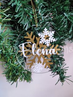 a glass ornament with snowflakes hanging from it's side on a christmas tree