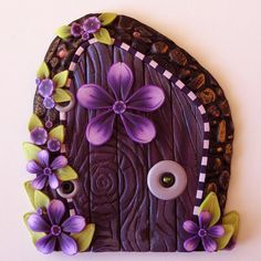 a purple fairy door with flowers on it