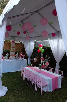 a party tent set up with pink and white tablecloths, balloons and decorations