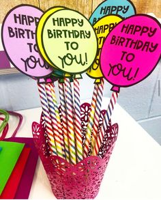 birthday candles are in a pink basket on a table