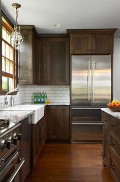 a kitchen with wooden cabinets and stainless steel appliances, including a double door refrigerator freezer