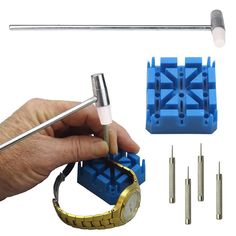 a hand holding a metal tool and some screws next to blue plastic blocks with holes in them