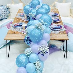 a long table with blue balloons and snowflakes on it, along with other decorations