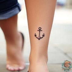 an anchor tattoo on the foot of a woman's leg is seen in this image