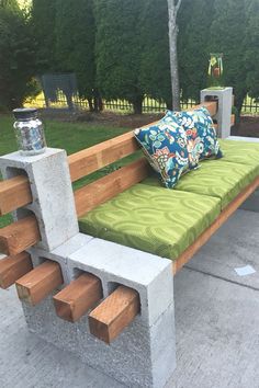 a bench made out of cinder blocks with pillows on the seat and back rest area