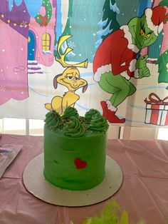 there is a green frosted cake with an image of the grinch on it