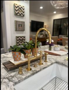 a kitchen with marble counter tops and gold faucets on the sink in front of it