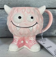 a ceramic mug with a smiling face on it's side and a price tag