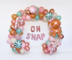 a wreath made out of balloons with the word oh snap spelled in pink and green