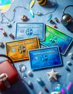 three american express credit cards sitting on top of a table next to some other items