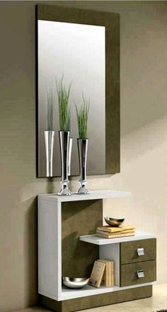 a mirror sitting on top of a wall next to a shelf with vases and plants