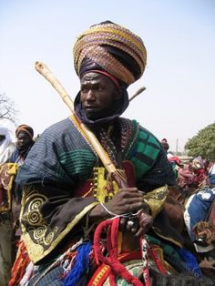 a man sitting on the back of a horse with a stick in it's mouth