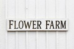 a sign on the side of a building that says flower farm in black and white